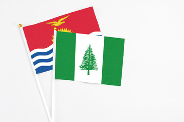 Norfolk Island and Kiribati stick flags on white background. High quality fabric, miniature national flag. Peaceful global concept.White floor for copy space.
