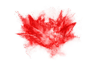 Freeze motion of red powder exploding, isolated on white background. Abstract design of red dust...