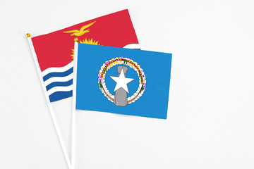 Northern Mariana Islands and Kiribati stick flags on white background. High quality fabric, miniature national flag. Peaceful global concept.White floor for copy space.