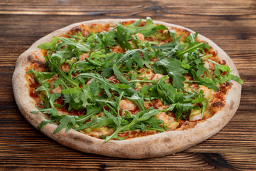 Prawn and cheese pizza with a bunch of fresh arugula