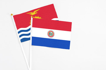 Paraguay and Kiribati stick flags on white background. High quality fabric, miniature national flag. Peaceful global concept.White floor for copy space.