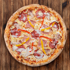 Meat pizza with ham and fresh bell pepper on wooden table
