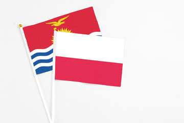 Poland and Kiribati stick flags on white background. High quality fabric, miniature national flag. Peaceful global concept.White floor for copy space.