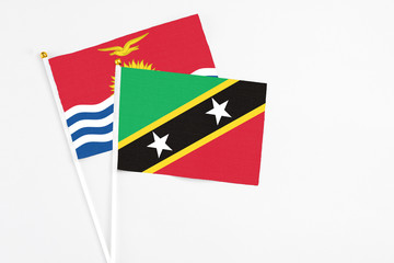 Saint Kitts And Nevis and Kiribati stick flags on white background. High quality fabric, miniature national flag. Peaceful global concept.White floor for copy space.