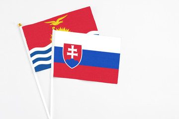 Slovakia and Kiribati stick flags on white background. High quality fabric, miniature national flag. Peaceful global concept.White floor for copy space.