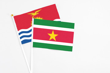 Suriname and Kiribati stick flags on white background. High quality fabric, miniature national flag. Peaceful global concept.White floor for copy space.
