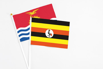 Uganda and Kiribati stick flags on white background. High quality fabric, miniature national flag. Peaceful global concept.White floor for copy space.