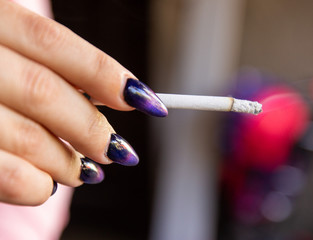 girl with big nails in her hands holding a cigarette