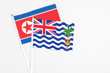 Fototapeta premium British Indian Ocean Territory and North Korea stick flags on white background. High quality fabric, miniature national flag. Peaceful global concept.White floor for copy space.