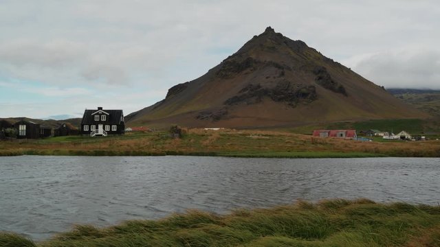 The small village of Hellnar across a lake, West Iceland