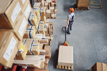 Top view of male worker in warehouse with pallet truck