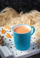 Christmas and New Year cozy holiday composition with mandarin, scarf, mugs with cocoa or chocolate on the white wooden tray background. Vertical view.