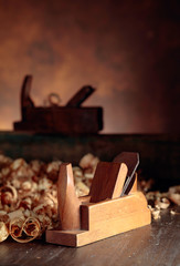 Old wooden jointer and shaving on wooden table.