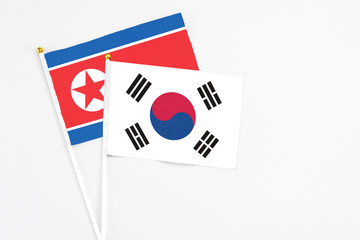 South Korea and North Korea stick flags on white background. High quality fabric, miniature national flag. Peaceful global concept.White floor for copy space.