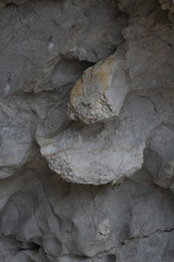 Rough texture of the rock in the grotto close-up in a gray background