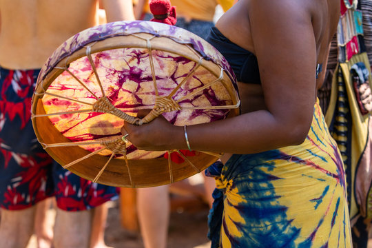 Sacred Drums During Spiritual Singing. A Close Up On Black Woman Hand Playing Shaman Drum During A Spiritual Ritual, With People In The Background