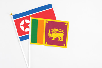 Sri Lanka and North Korea stick flags on white background. High quality fabric, miniature national flag. Peaceful global concept.White floor for copy space.