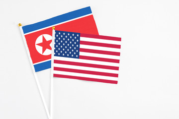 United States and North Korea stick flags on white background. High quality fabric, miniature national flag. Peaceful global concept.White floor for copy space.