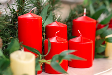 Christmas decorations red wax candles on white fireplace