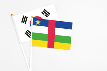 Central African Republic and South Korea stick flags on white background. High quality fabric, miniature national flag. Peaceful global concept.White floor for copy space.