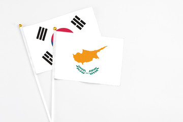 Cyprus and South Korea stick flags on white background. High quality fabric, miniature national flag. Peaceful global concept.White floor for copy space.