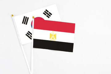 Egypt and South Korea stick flags on white background. High quality fabric, miniature national flag. Peaceful global concept.White floor for copy space.