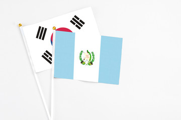 Guatemala and South Korea stick flags on white background. High quality fabric, miniature national flag. Peaceful global concept.White floor for copy space.