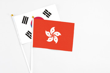 Hong Kong and South Korea stick flags on white background. High quality fabric, miniature national flag. Peaceful global concept.White floor for copy space.