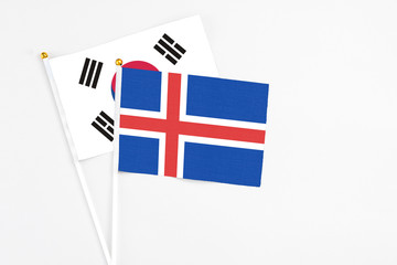 Obraz premium Iceland and South Korea stick flags on white background. High quality fabric, miniature national flag. Peaceful global concept.White floor for copy space.
