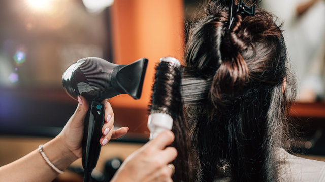 Hairdresser Curling Woman’s Hair