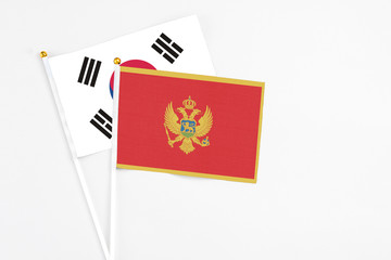 Montenegro and South Korea stick flags on white background. High quality fabric, miniature national flag. Peaceful global concept.White floor for copy space.