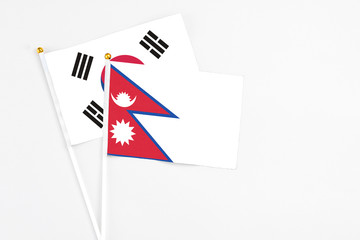 Nepal and South Korea stick flags on white background. High quality fabric, miniature national flag. Peaceful global concept.White floor for copy space.