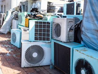 old air conditioners on street next to repair shop