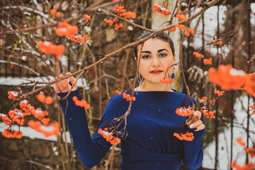 Fototapeta na wymiar Young arabic woman at winter day in pretty blue dress on a snowy yard 