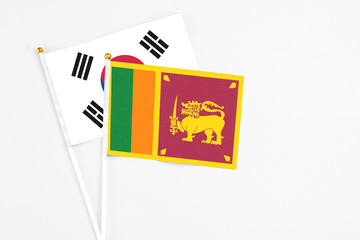 Sri Lanka and South Korea stick flags on white background. High quality fabric, miniature national flag. Peaceful global concept.White floor for copy space.