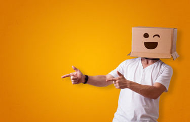 Funny man wearing cardboard box on his head with smiley face