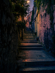 Obraz premium Vertical photo of a narrow alley at night in the city of Dubrovnik