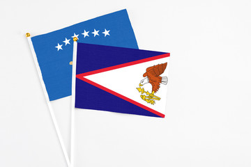 American Samoa and Kosovo stick flags on white background. High quality fabric, miniature national flag. Peaceful global concept.White floor for copy space.
