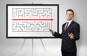 Handsome businessman with laser pointer presenting potential exit from a labyrinth