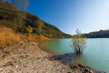 Lago di Tenno in autumn, small beautiful lake in Italian Alps. Trento province, Trentino-Alto Adige, Italy, Europe