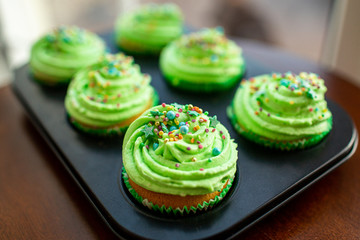 Cupcakes with green cream, selective focus. Sent Patrick decoration. Selective focus.