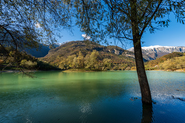 Lago di Tenno in autumn with island, small beautiful lake with reflections in Italian Alps (Giudicarie) Trento province, Trentino-Alto Adige, Italy, Europe