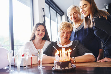 Senior woman with family and friends celebrating a birthday indoors