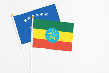 Ethiopia and Kosovo stick flags on white background. High quality fabric, miniature national flag. Peaceful global concept.White floor for copy space.