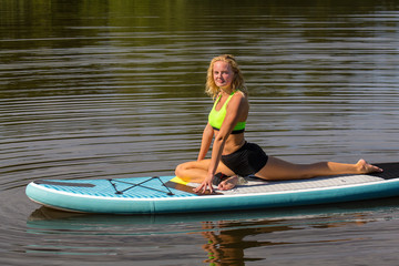 Young woman in yoga swan posture on SUP