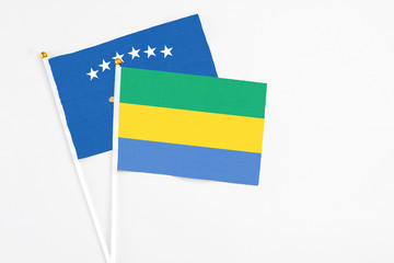 Gabon and Kosovo stick flags on white background. High quality fabric, miniature national flag....