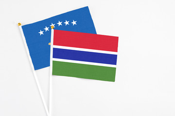Gambia and Kosovo stick flags on white background. High quality fabric, miniature national flag. Peaceful global concept.White floor for copy space.