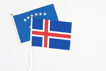 Obraz premium Iceland and Kosovo stick flags on white background. High quality fabric, miniature national flag. Peaceful global concept.White floor for copy space.