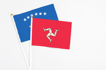 Isle Of Man and Kosovo stick flags on white background. High quality fabric, miniature national flag. Peaceful global concept.White floor for copy space.