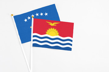 Kiribati and Kosovo stick flags on white background. High quality fabric, miniature national flag. Peaceful global concept.White floor for copy space.